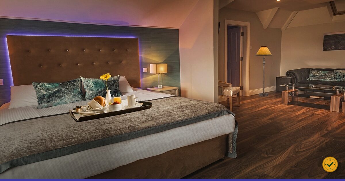Hotel bed beside a bedside lamp