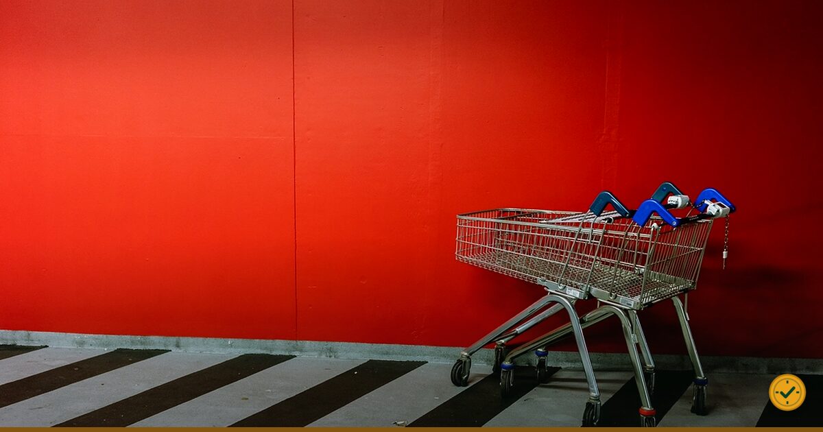 Shopping trolley against a red wall