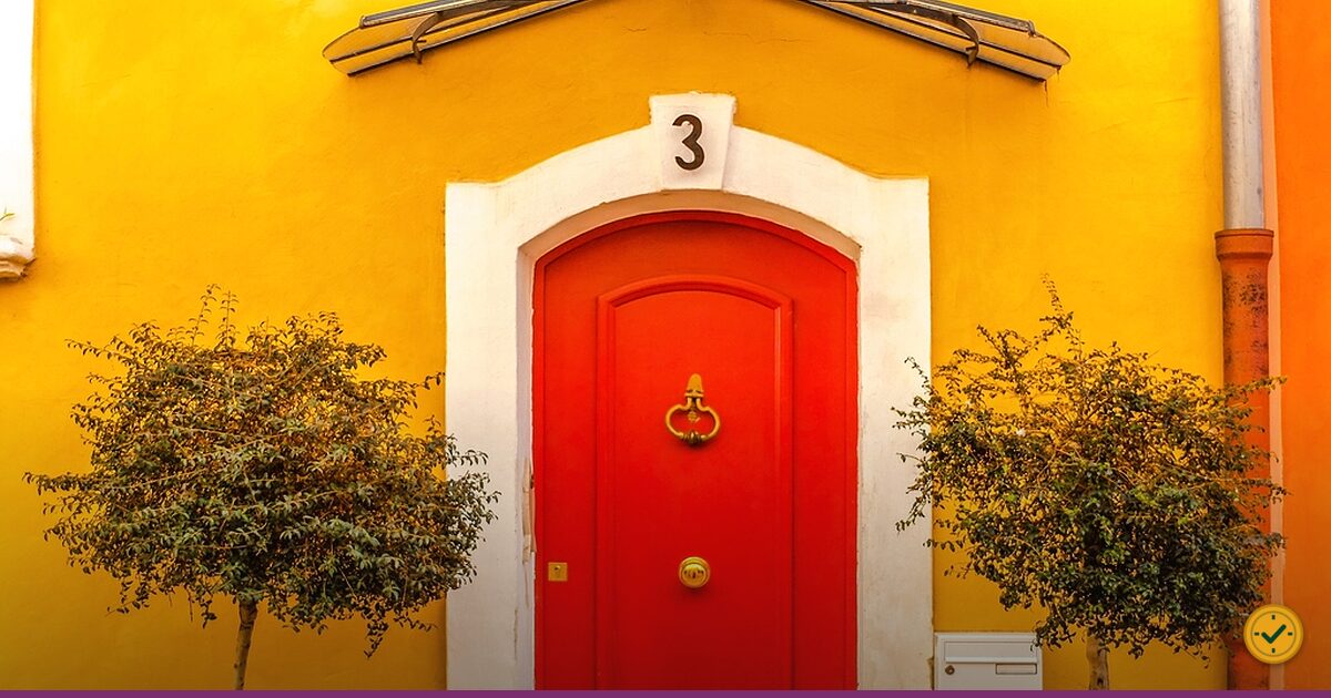 Red front door with a brass knocker